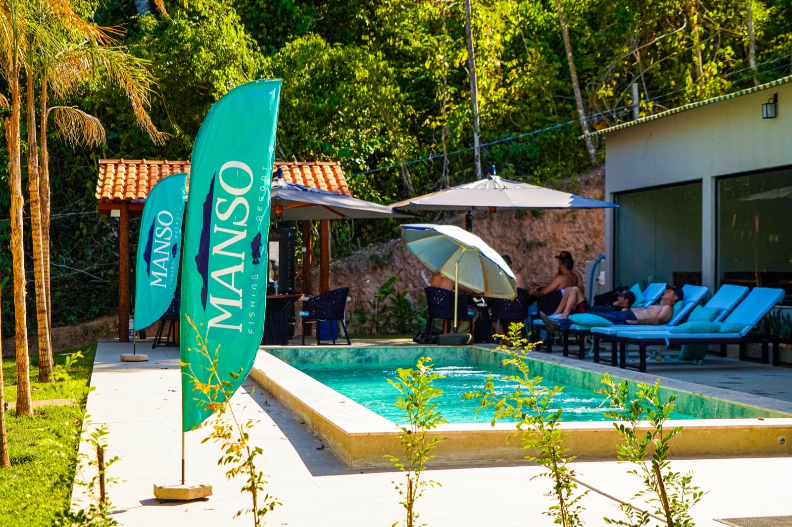 Piscina do resort com espreguiçadeiras e mata nativa ao fundo