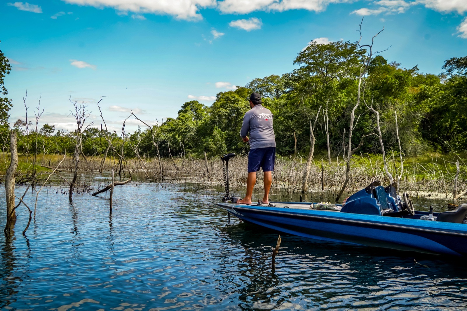 Pescador lançando isca entre os paliteiros do Lago do Manso